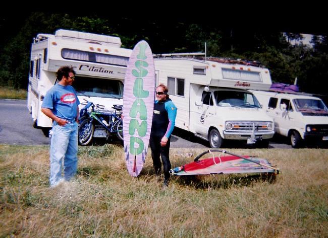 Johnny  Doo Bad
Here's an old one of Johnny with his favourite ,, Gorge Animal Bonser 7'6",,,,, still at cook ,,, that was his motorhome in the background to the right.. ,,taken about 1992, Island Sails was the name of his sail loft ,,, he had this board custom made in the Gorge with  "Island" graphics on the bottom...that was when he lived on 10 mile point with Jose and Kevin.... long time ago... can see his logo on his motorhome door ,,, ,,,  slim and trim in those days ,, 
